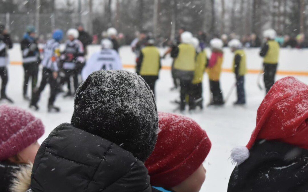 Jääkiekko-ottelun katsojia Muuramen koulun tekojään avajaisissa talvella 2023-2024